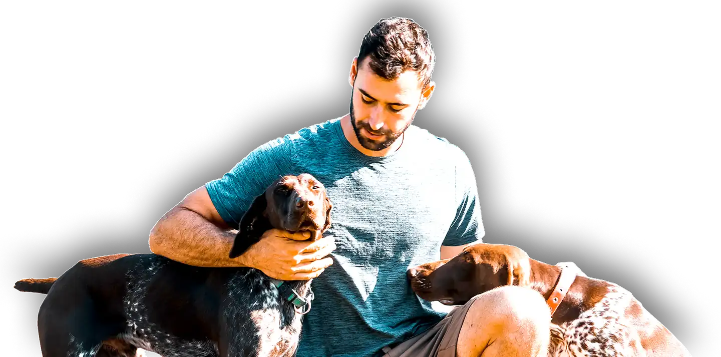Good Dog Training Business owner Ryan patting two dogs.