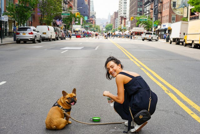 lady and dog standing in street